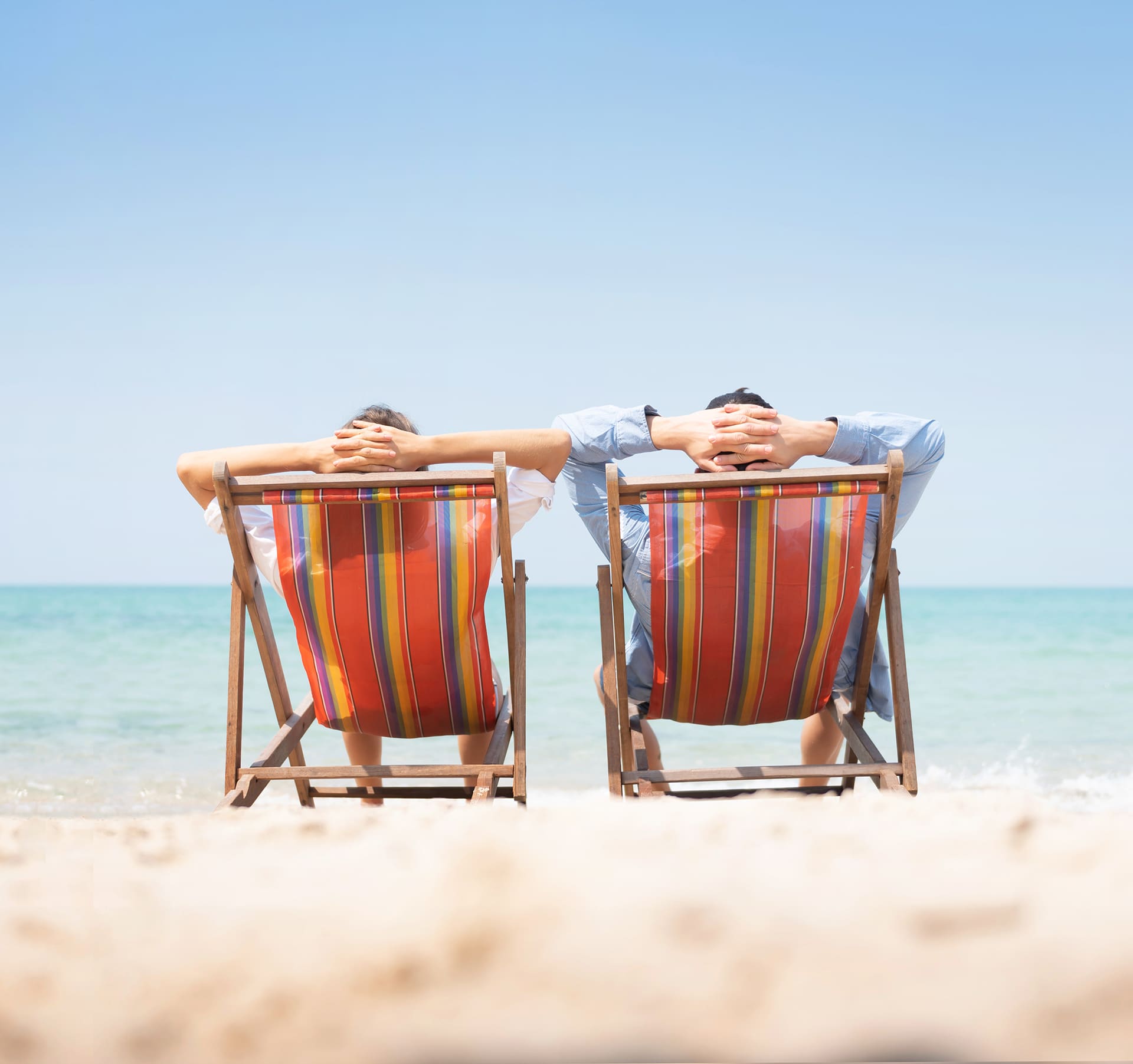 2 personnes sur des transat à la plage - © iStock