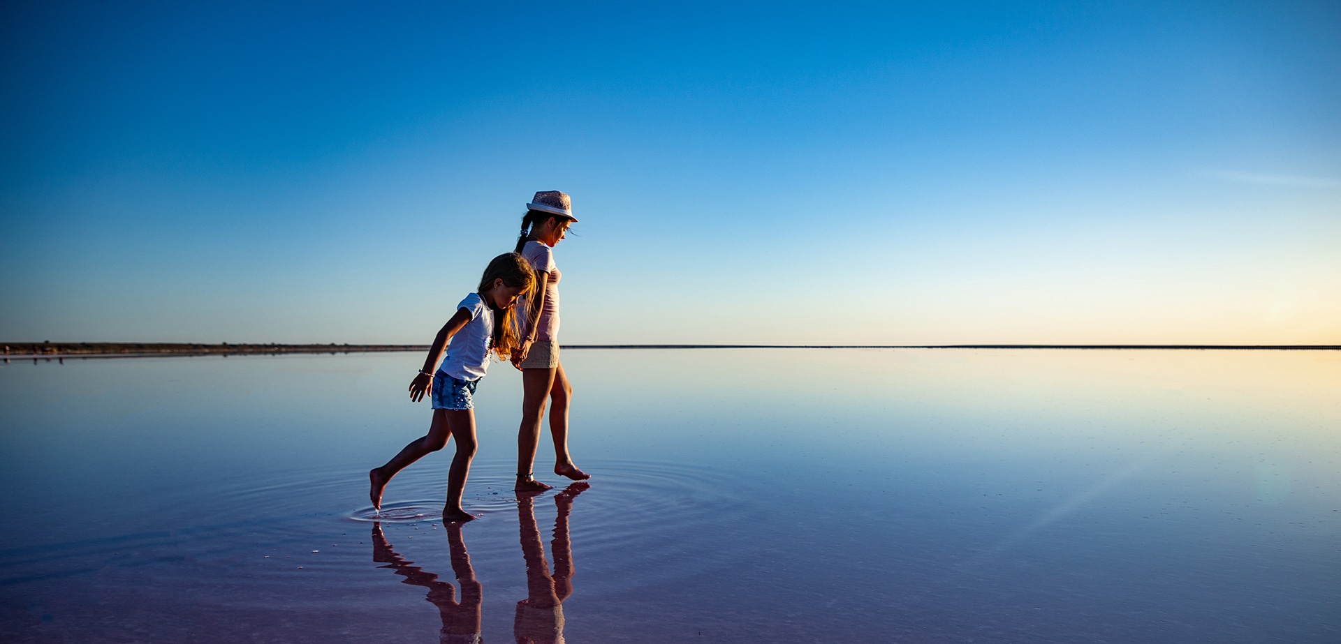 2 enfants marche sur l'eau à la mer - © iStock