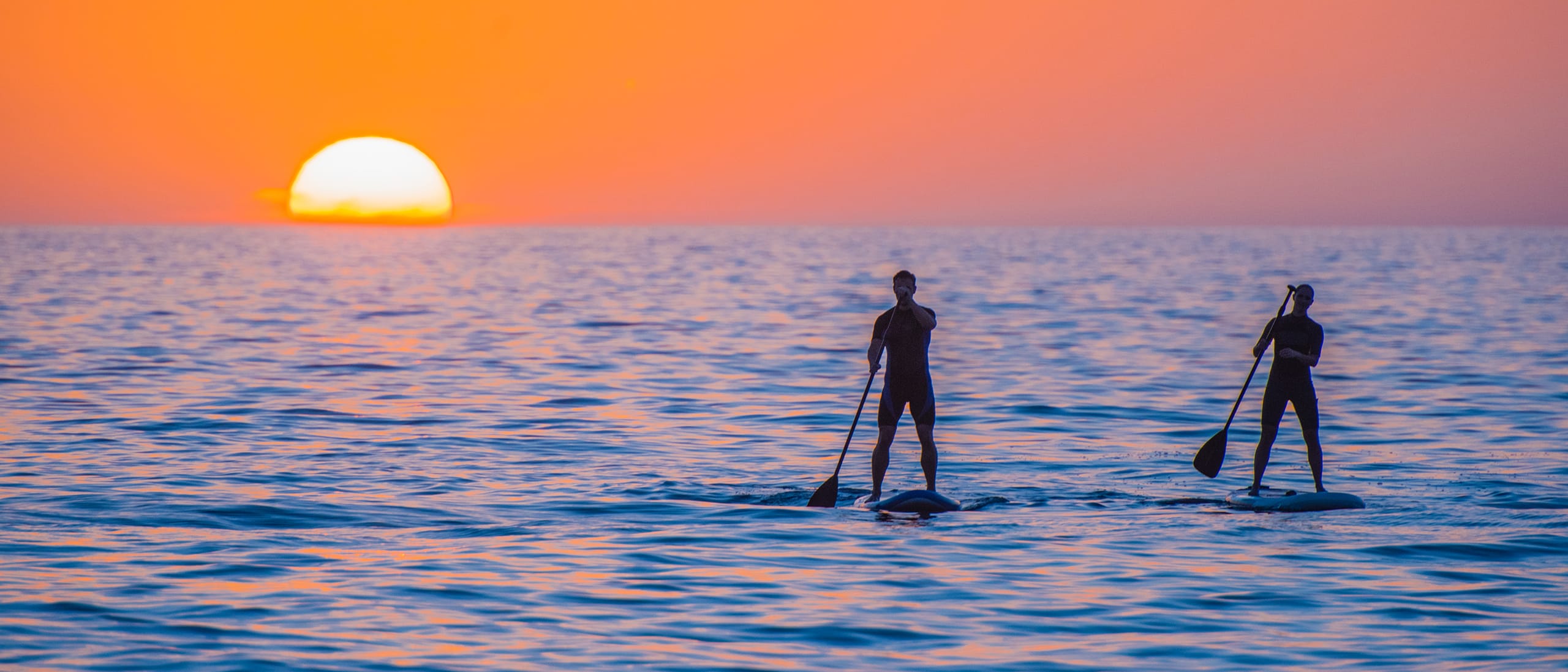 2 personnes font du paddle au coucher de soleil - © iStock